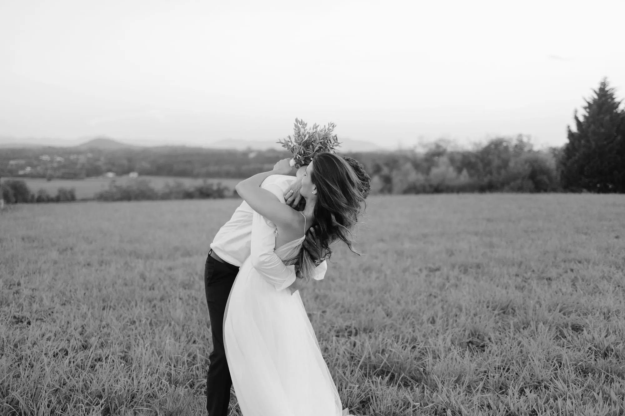 Couple de jeunes mariés allongés dans l'herbe, photographie en noir et blanc